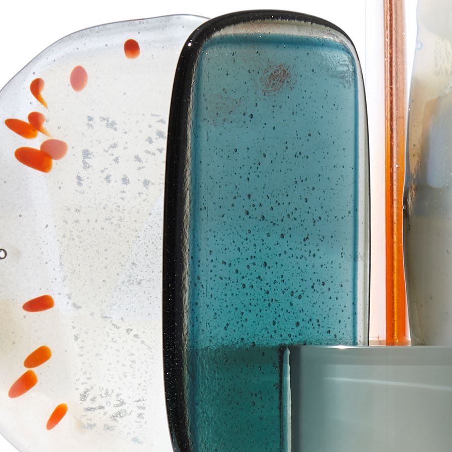 rich green grey cylinder with colour fade towards the top with five rounded abstract finials overlapping the top edge in orange steel opaque white and clear hand made from blown and fused glass